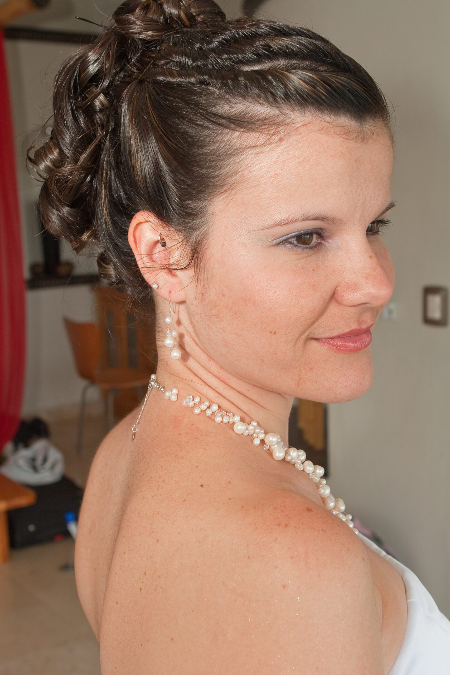 This is a close-up photo of Anna's earrings and her necklace. They are both made of pearls. It also shows her hairstyle. When she went to the place to get her hair done. She told them to glued it down. When she wound up removing all the pins and clips that evening, her hair stayed perfectly put. I have no wave describing the way her hair looks.